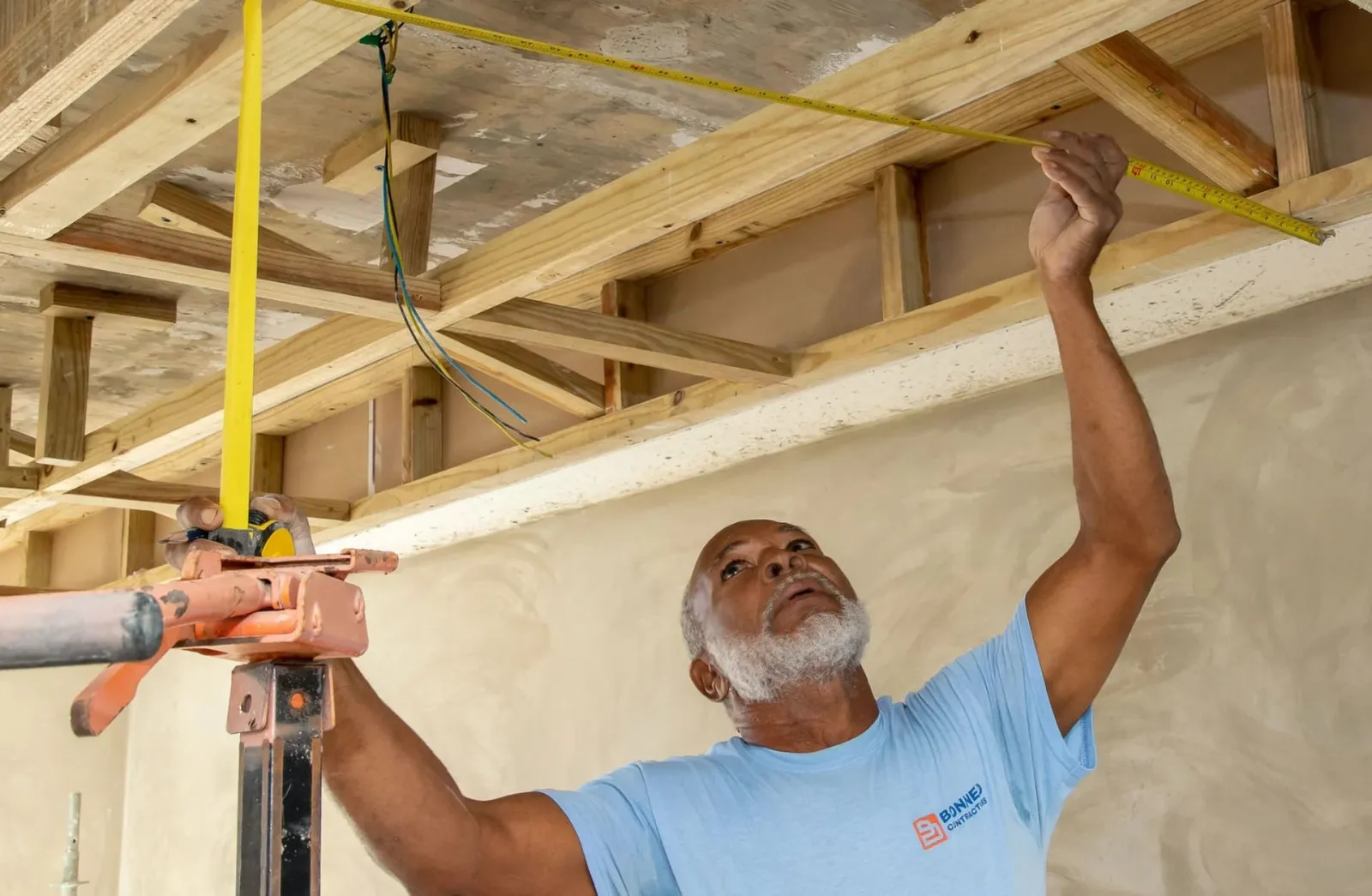Timmerman van BONNED meet een houten constructie uit